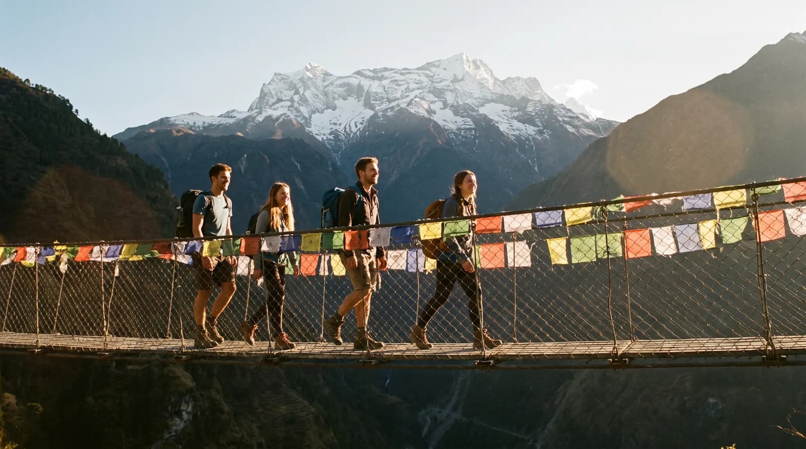 Young trekkers crossing a suspension bridge in the nepa