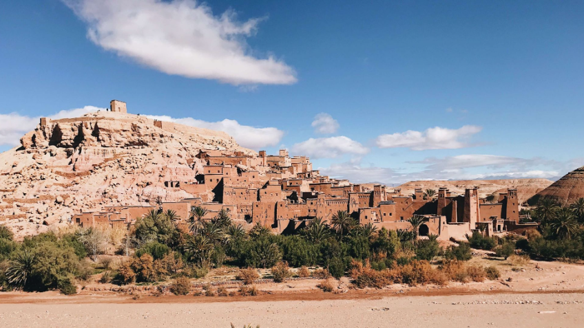 Aït Benhaddou is a fortified village located in Morocco, known for its unique architecture and historic significance as a UNESCO World Heritage Site. The village features tall earthen buildings and narrow alleys, and is situated on a hill overlooking a river.