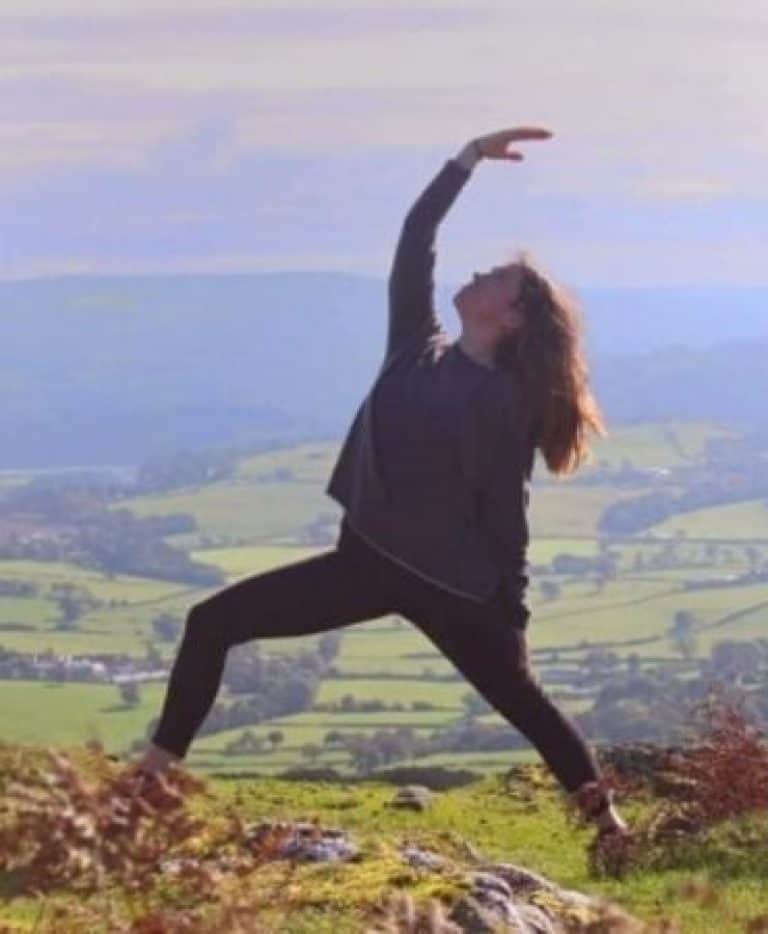 Young woman doing yoga pose on a Contiki Wellness tour in Wales, England