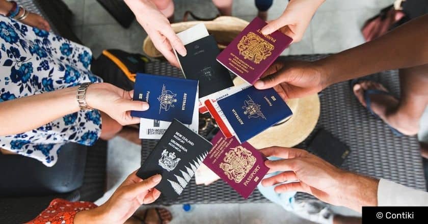 Travellers holding their passports forming a circle with different nationalities of passports showing