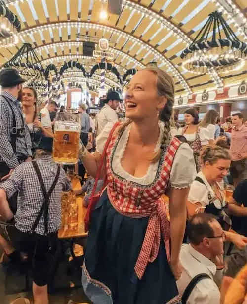 A woman wearing lederhosen is embracing a traditional German attire typically worn during cultural celebrations and events.