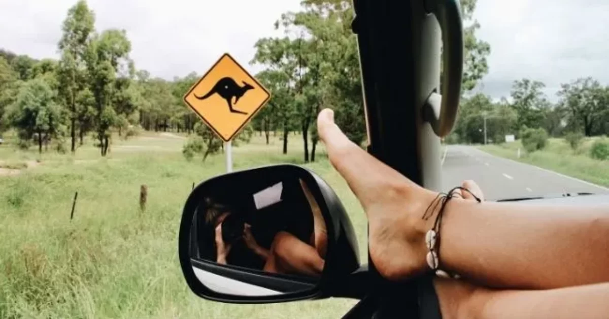 Girl with foot on car window Australian road trip