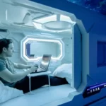 An interior view of the Capsule Hotel Lucerne showing several individual capsules stacked vertically with blue mood lighting and personal TVs.