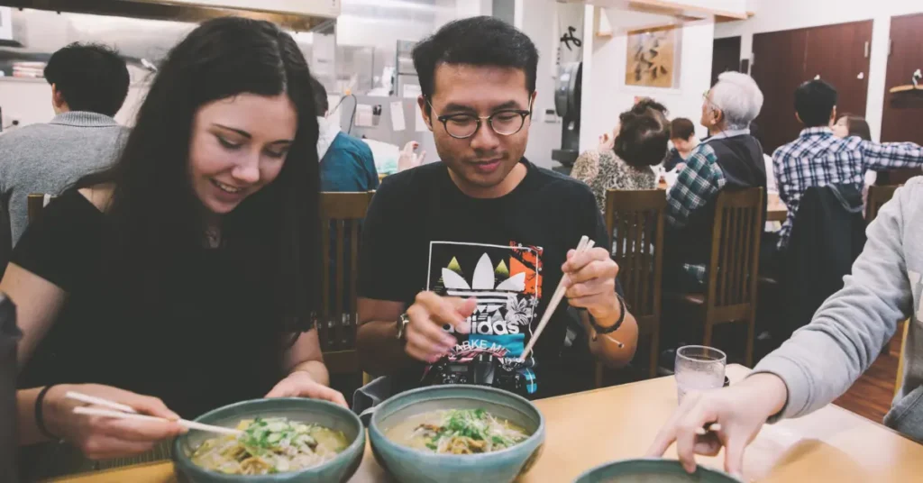 Group of travellers sharing a local meal in Japan during a Topdeck tour.