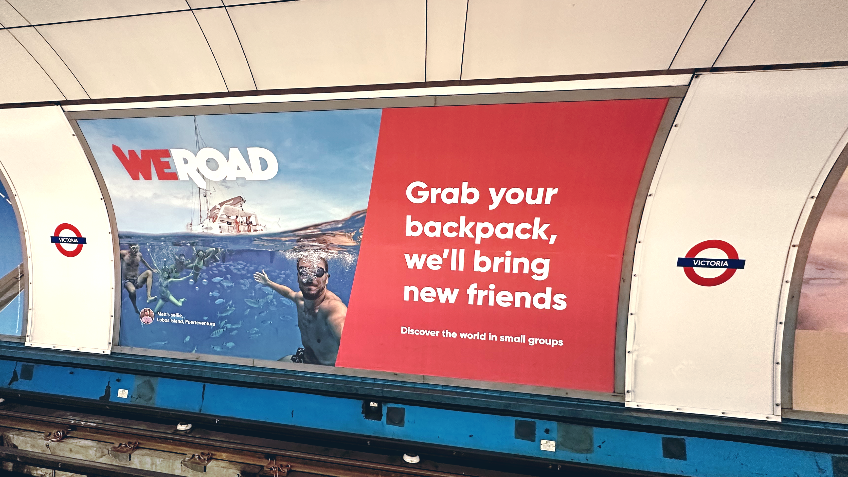 "Grab your backpack, we'll bring new friends" ad campaign by WeRoad Travel on the London Underground network