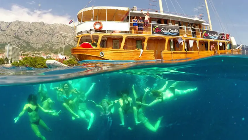 A group of young travellers swimming under the clear waters in Croatia