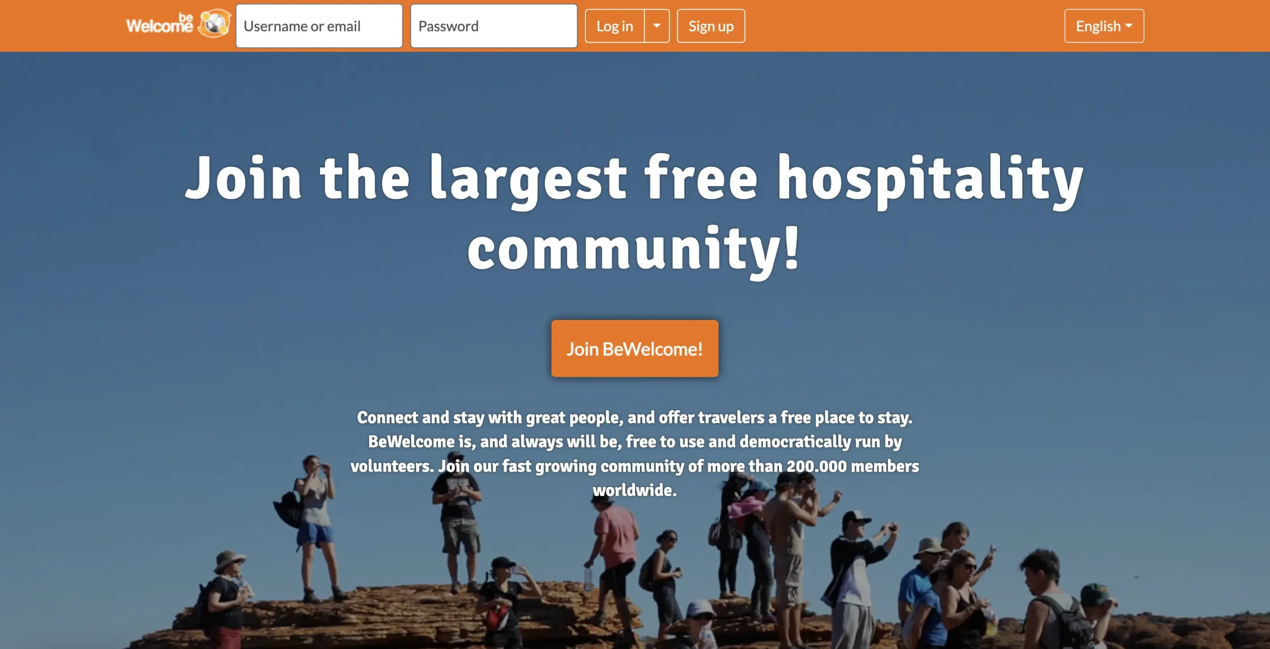 BeWelcome website's call-to-action banner inviting users to join the largest free hospitality community with a backdrop of travellers on a rocky outcrop