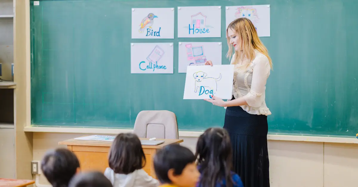 An English teacher in South Korea uses visual aids to teach vocabulary to young students in a classroom.