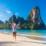 A captivating image showcasing a beautiful beach in Thailand, featuring soft golden sands, turquoise waters, and dramatic limestone cliffs. The scene captures the essence of paradise, inviting exploration and relaxation amidst a serene natural landscape.