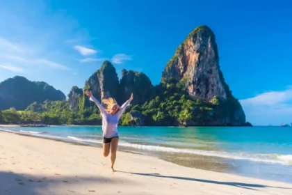 A captivating image showcasing a beautiful beach in Thailand, featuring soft golden sands, turquoise waters, and dramatic limestone cliffs. The scene captures the essence of paradise, inviting exploration and relaxation amidst a serene natural landscape.